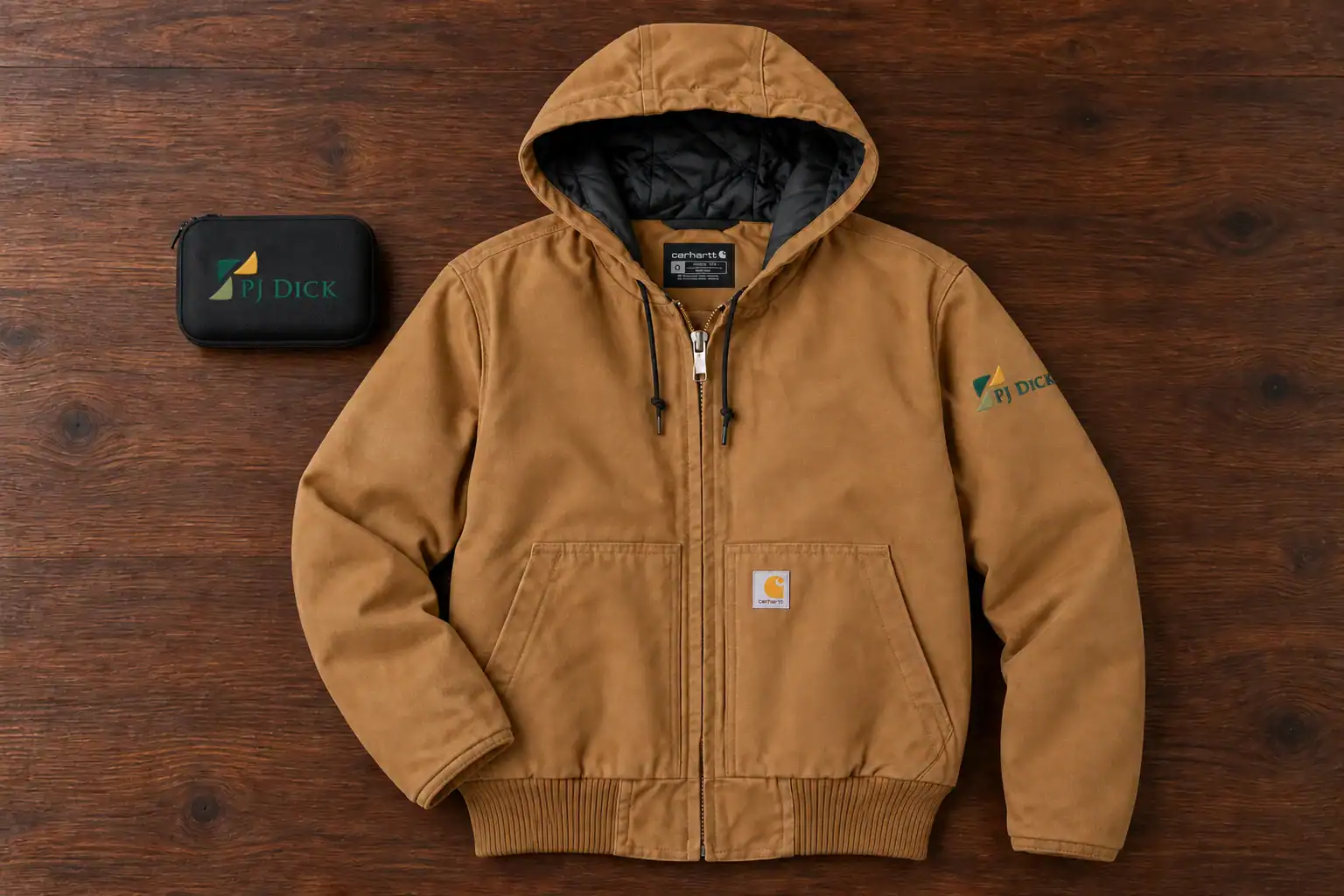 Tan work jacket with a PJ Dick logo and a branded tech case