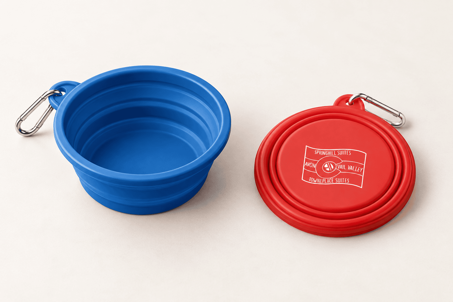 Blue and red collapsible pet bowls with a hotel logo