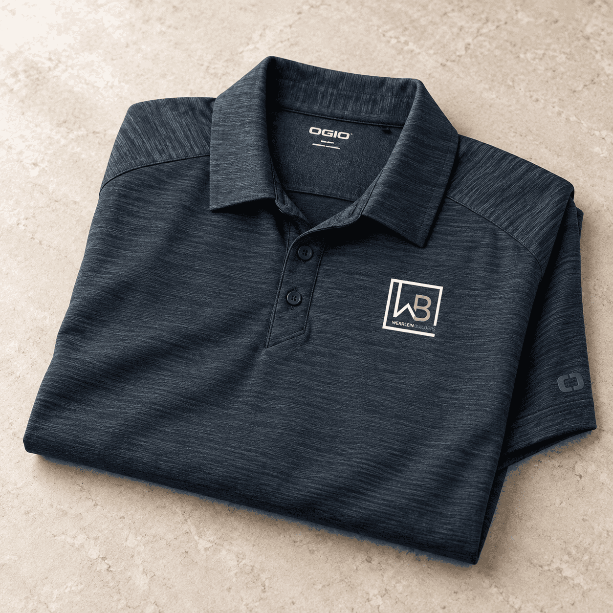 Close-up of an embroidered monogram on a charcoal performance polo